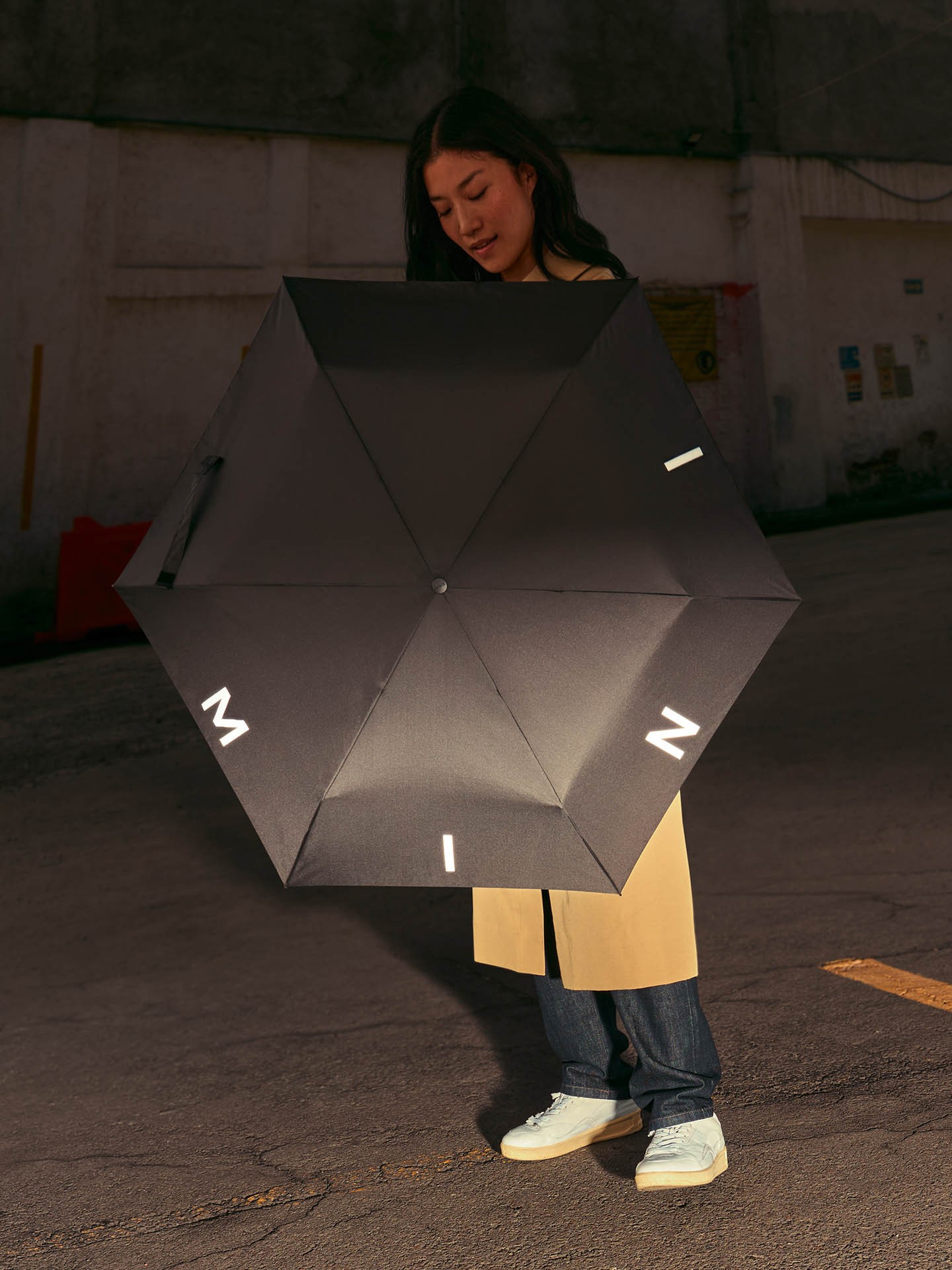 Female model holds a black MINI umbrella